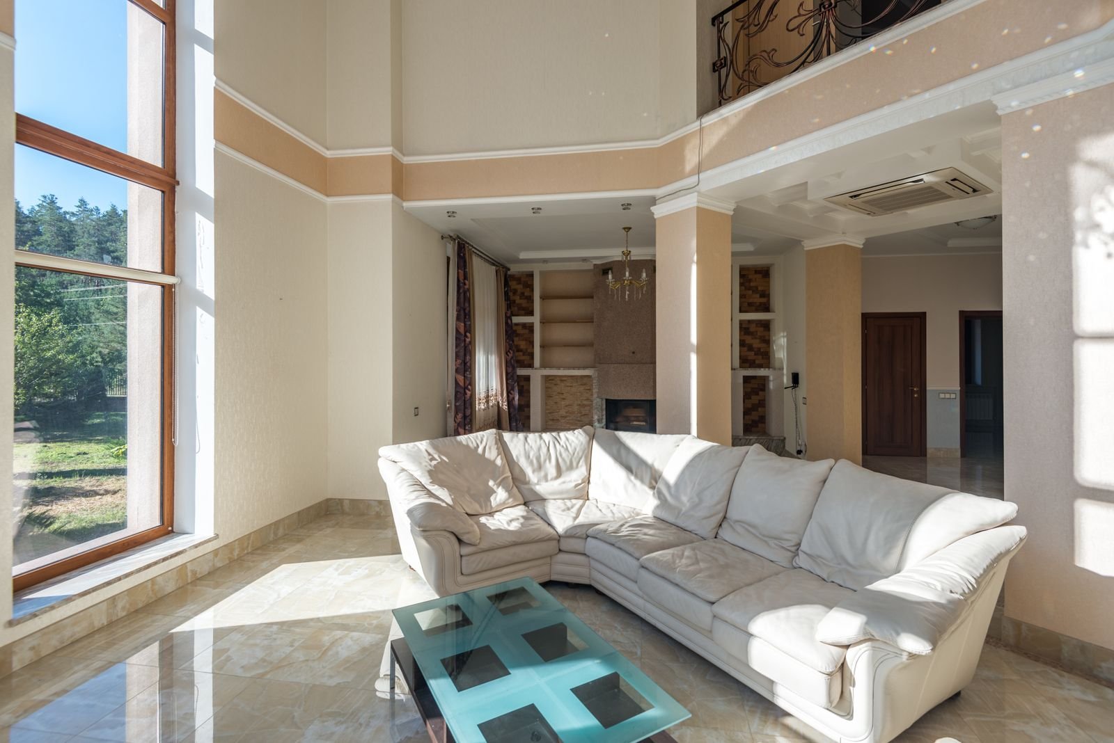 Bright living room with a white sectional sofa and large windows